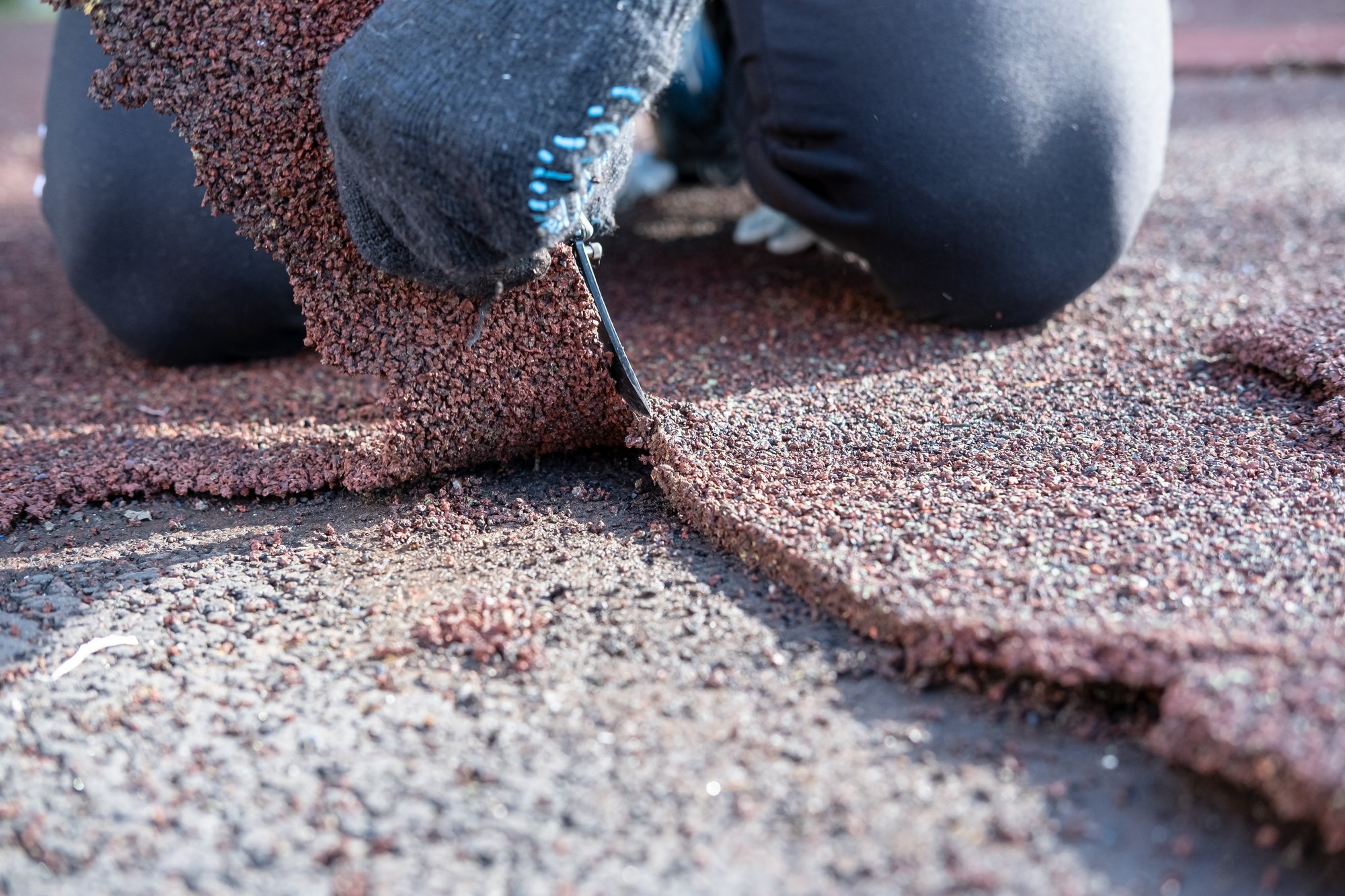 Close-up of roofing contractor installing asphalt shingles during a residential roof inspection or repair